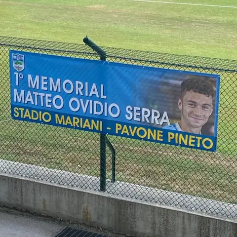 Striscione del 1° Memorial Matteo Ovidio Serra sulla recinzione dello stadio Mariani–Pavone di Pineto